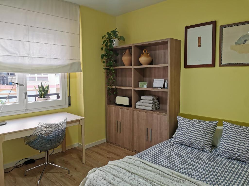 略夫雷加特河畔奥斯皮塔莱特Dos habitaciones dobles en apartamento confortable的一间卧室配有一张床、一张书桌和一个窗户。