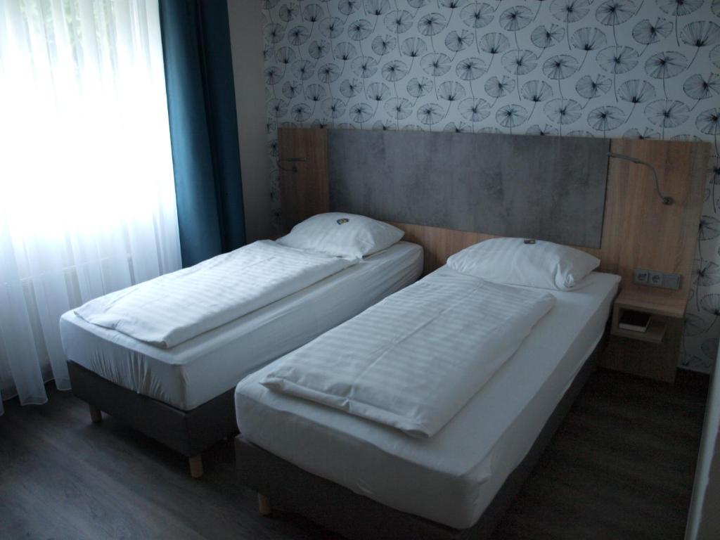 科隆科隆机场商业酒店的带窗户的客房内设有两张单人床。