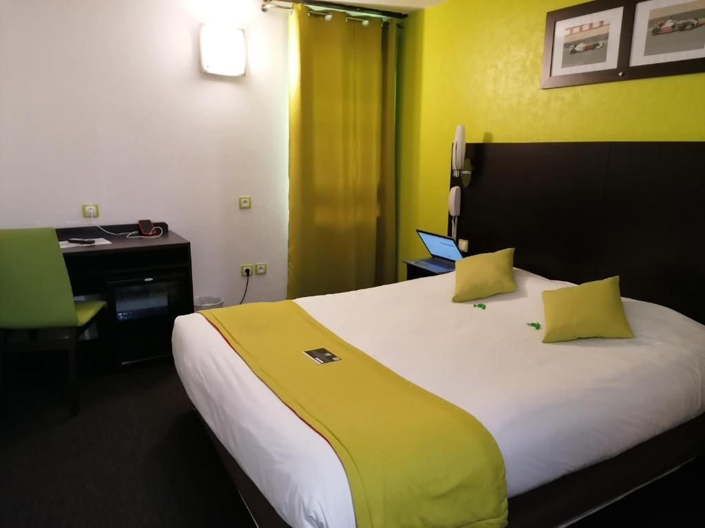 维耶尔宗Enzo Hotels Vierzon by Kyriad Direct的酒店客房配有一张带黄色枕头的大床