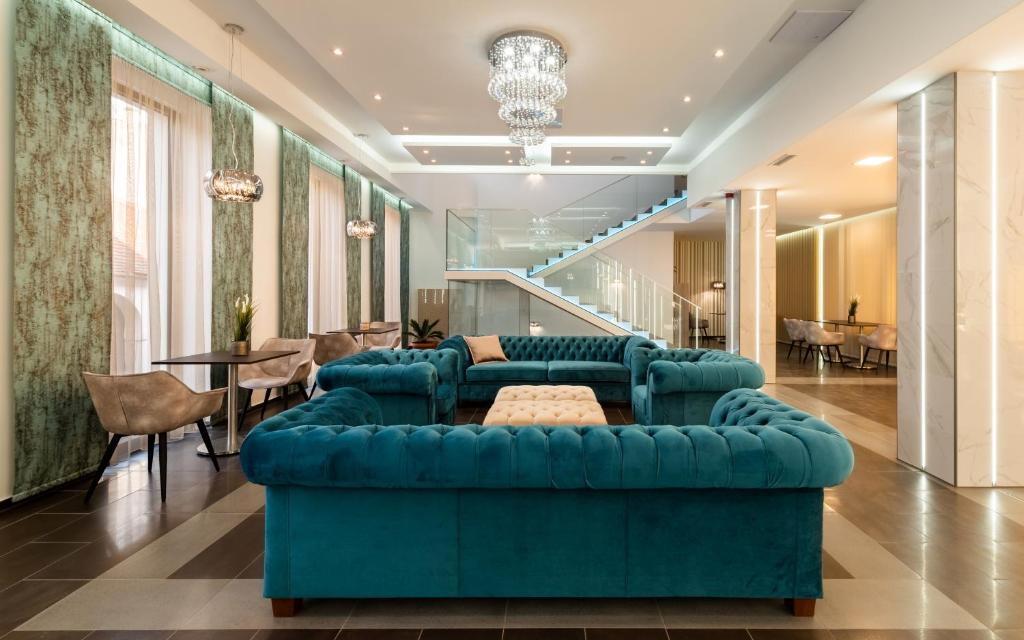 佩奇Fibula Residence Hotel & Wellness - Adults Only的客厅配有蓝色的沙发和桌子