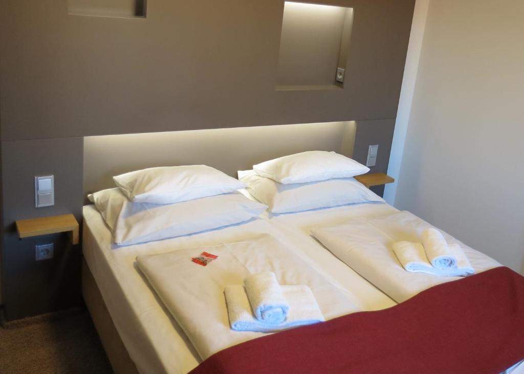 乌尔姆纽托尔酒店的一张大床,配有毛巾和枕头
