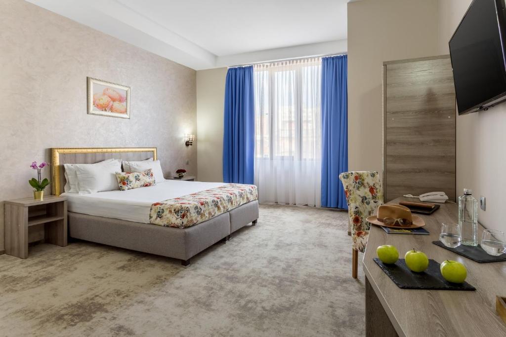 克拉约瓦Prestige Boutique Hotel Craiova的酒店客房配有一张床、一张书桌