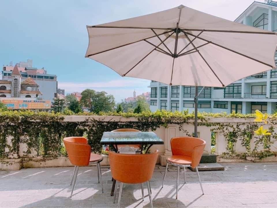 三岛县Hà Thành Tam Đảo HOTEL的庭院内桌椅和遮阳伞