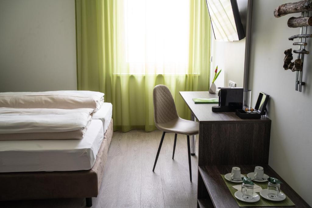 Neupirkaeee Hotel Graz的一间卧室配有一张桌子和一张床,一张桌子和椅子