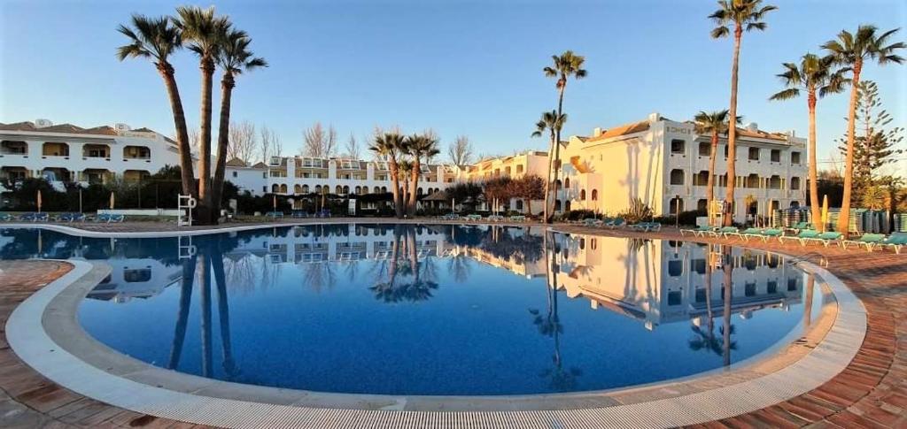 卡巴纳斯·德·塔维拉Casa Marias I - inserido no Resort Golden Club Cabanas的一座棕榈树和建筑的大型游泳池