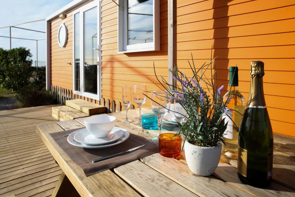 加瓦露营3艾斯特乐拉斯酒店的一张木桌,上面放着一瓶葡萄酒,一个杯子和一个盘子