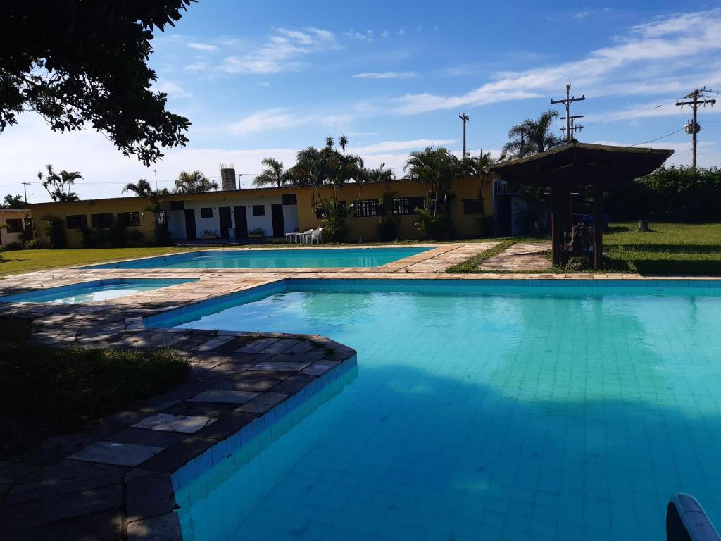 伊利亚孔普里达Samburá Chalés的一座蓝色的大型游泳池,其建筑背景为: