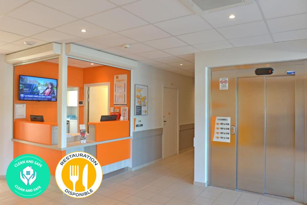 BéthenyPremiere Classe Reims Nord - Bétheny的一个带橙色墙壁和电梯的办公室大堂