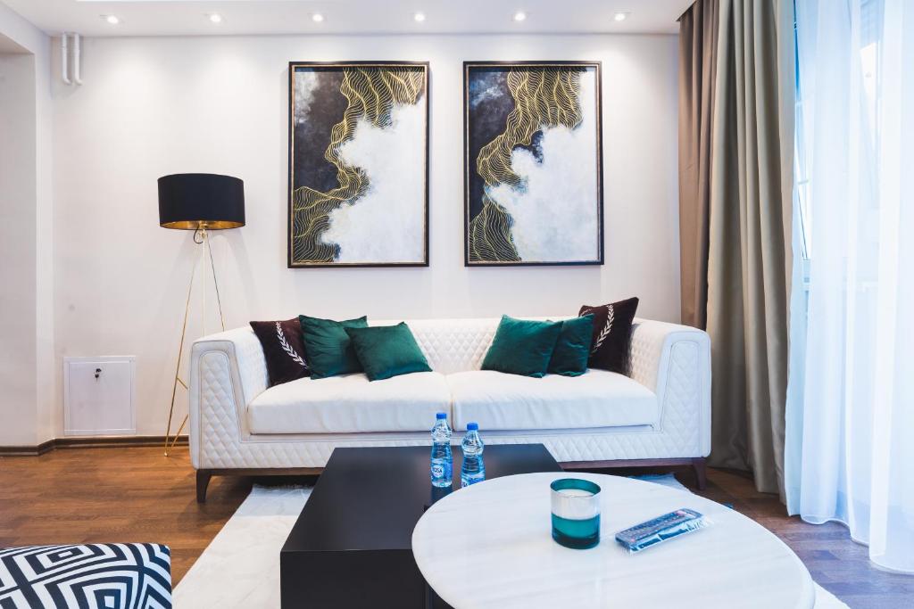 雅戈丁那Majestic Apartment的客厅配有带绿色枕头的白色沙发
