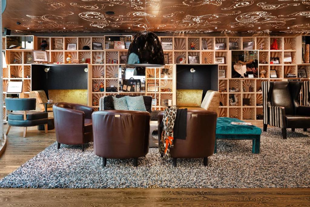 赫尔辛基斯堪迪克帕西酒店的带沙发和椅子的客厅(铺在地毯上)