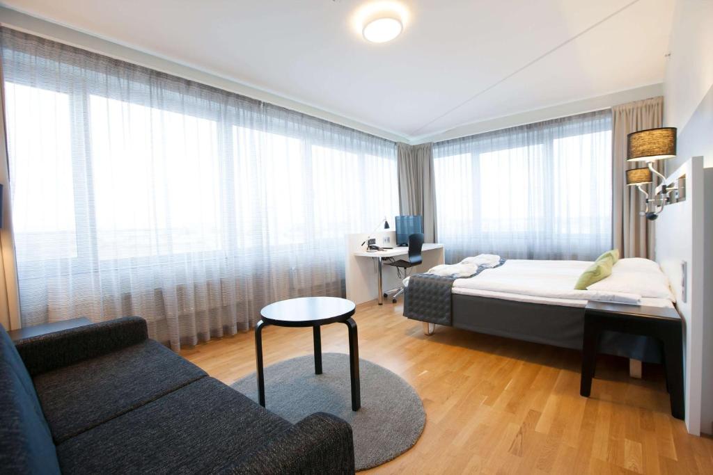 波里斯堪迪克波里酒店的一间卧室配有一张床、一张沙发和一张桌子