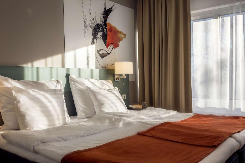 坦佩雷斯堪迪克罗森达尔酒店的卧室内的一张大床,设有窗户