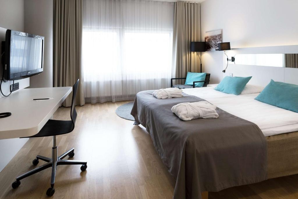 图尔库斯堪迪克朱莉娅酒店的酒店客房配有两张床和一张书桌