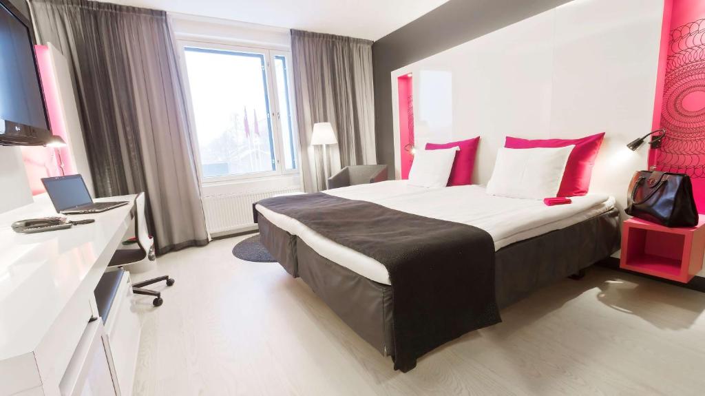 坦佩雷坦佩雷车站斯堪迪克酒店的酒店客房配有一张带红色枕头的大床