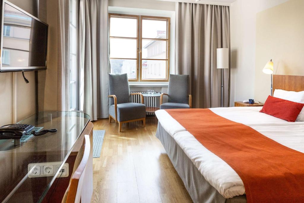 图尔库图尔库斯堪迪克广场酒店的酒店客房设有一张床铺和一张玻璃桌
