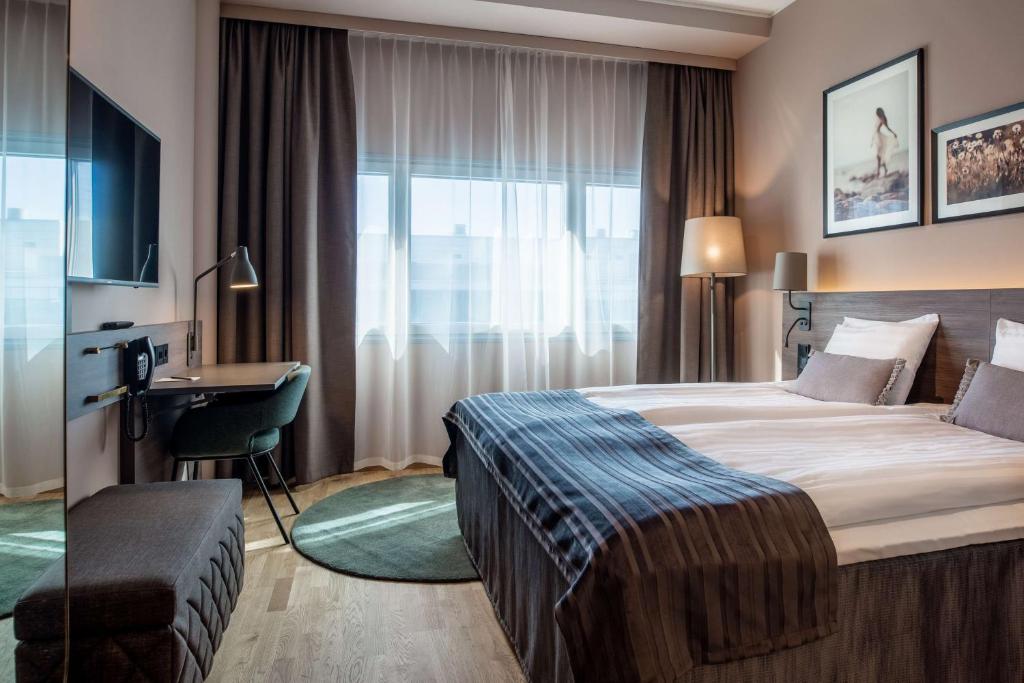 万塔赫尔辛基机场斯堪迪克酒店的配有一张床和一张书桌的酒店客房