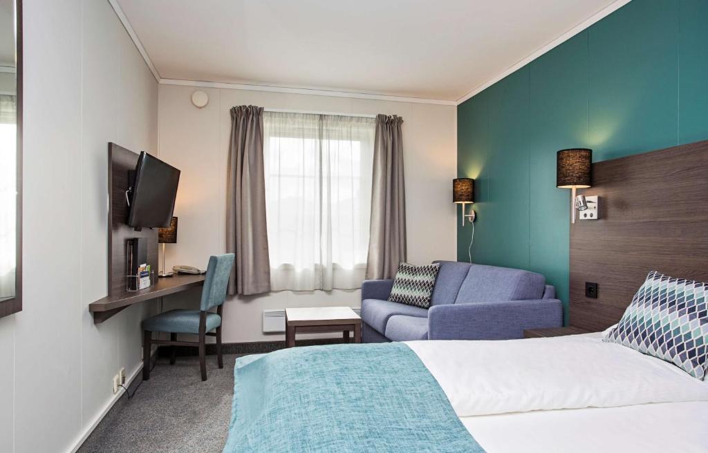 莱克内斯斯堪迪克莱克内斯罗弗敦酒店的酒店客房配有1张床、1台电视和1张沙发。