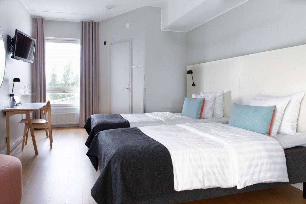 万塔Scandic Helsinki Aviapolis的酒店客房设有一张大床和一张书桌。