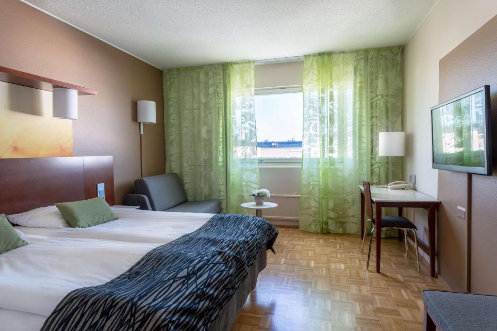 于韦斯屈莱于韦斯屈莱市斯甘迪克公寓的配有一张床、一张书桌和一扇窗户的酒店客房