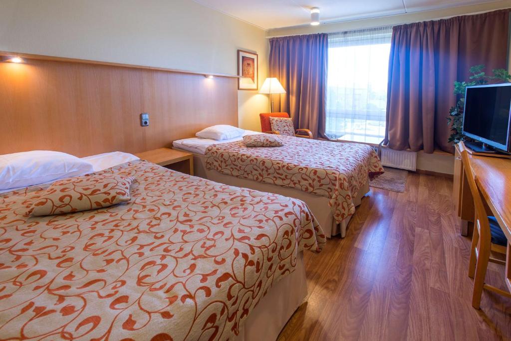 凯米凯米斯堪迪酒店的酒店客房设有两张床和一台平面电视。