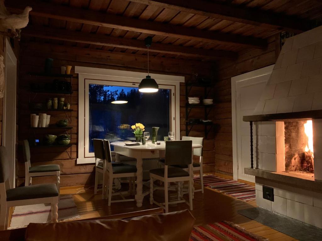 萨利色尔卡Saariselällä, sielukas hirsimökki - Unique cottage的一间带桌子和壁炉的用餐室