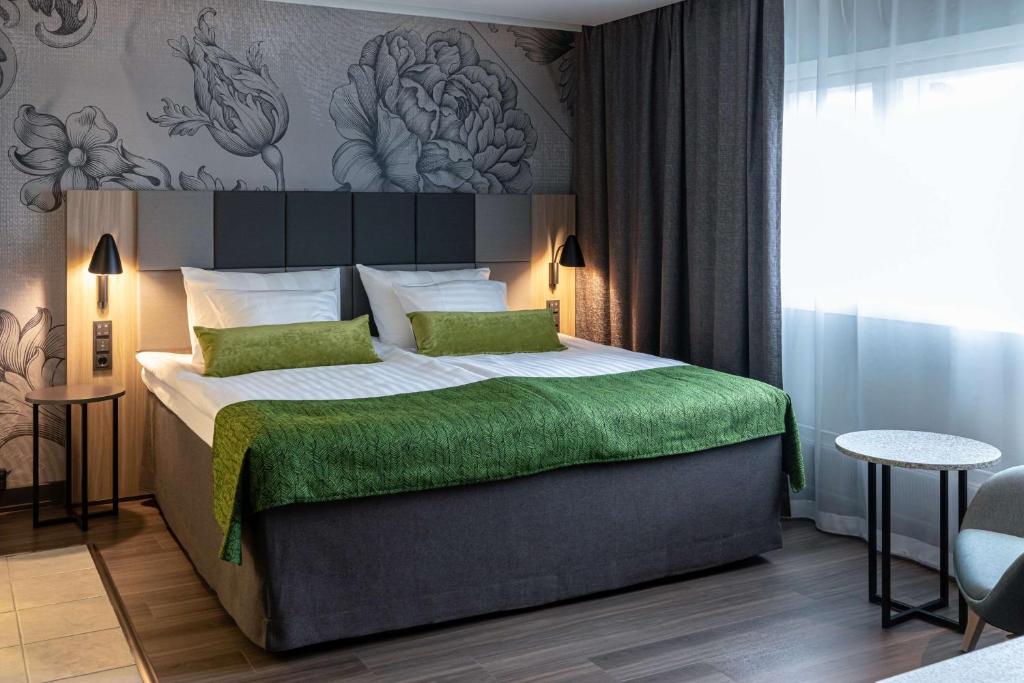 赫尔辛基Scandic Pasila的一间卧室配有一张带绿毯的大床