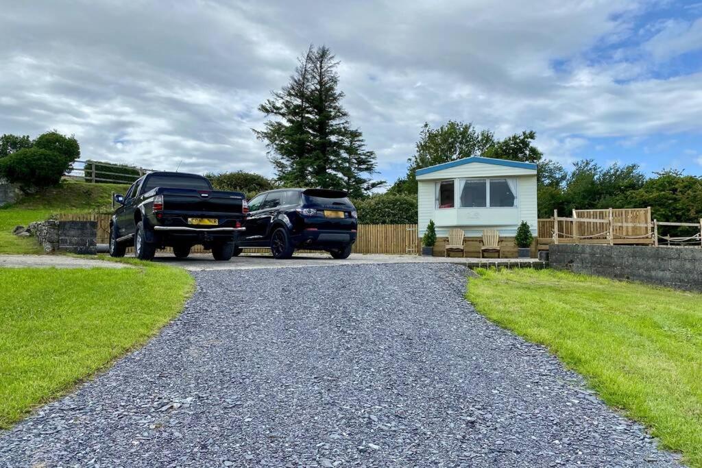 普尔赫利Snowdon Bay - North Wales - Stunning Llyn Peninsula Mountain & Ocean Views的停在小房子前面的两辆卡车