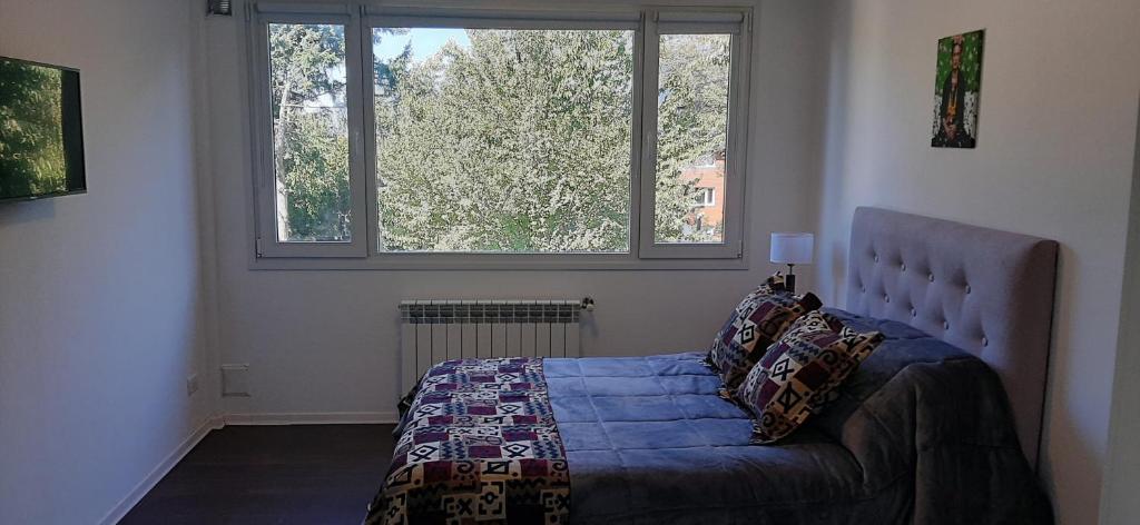 圣卡洛斯-德巴里洛切Departamento en Barrio Centrico Bariloche (PE)的一间卧室设有一张床和两个窗户。