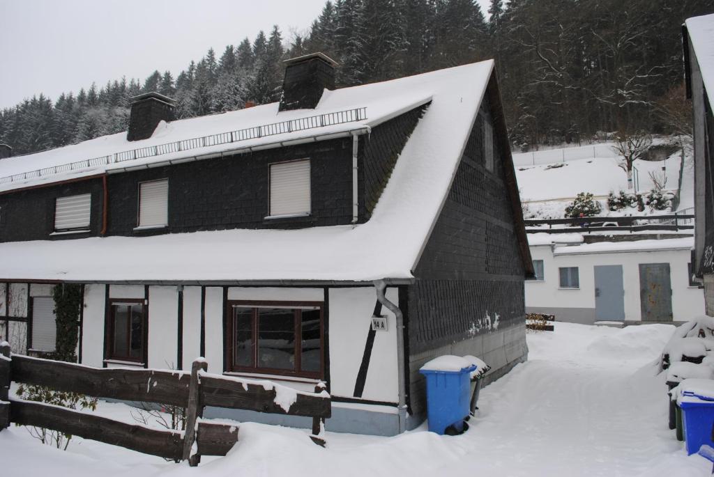 RamsbeckVakantiehuis Ramsbeck的屋顶上积雪的黑色房子