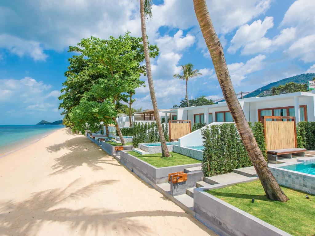 班邦宝White Whale Beachfront Pool Villa的棕榈树海滩和度假村