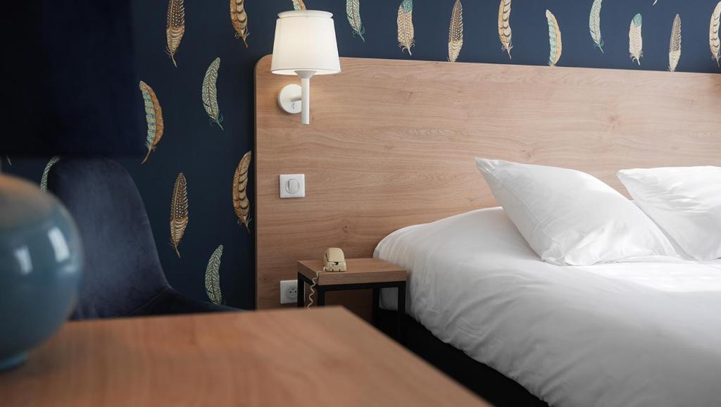 萨尔特河畔拉叙兹圣路易斯之家酒店的卧室配有一张带白色枕头和桌子的床