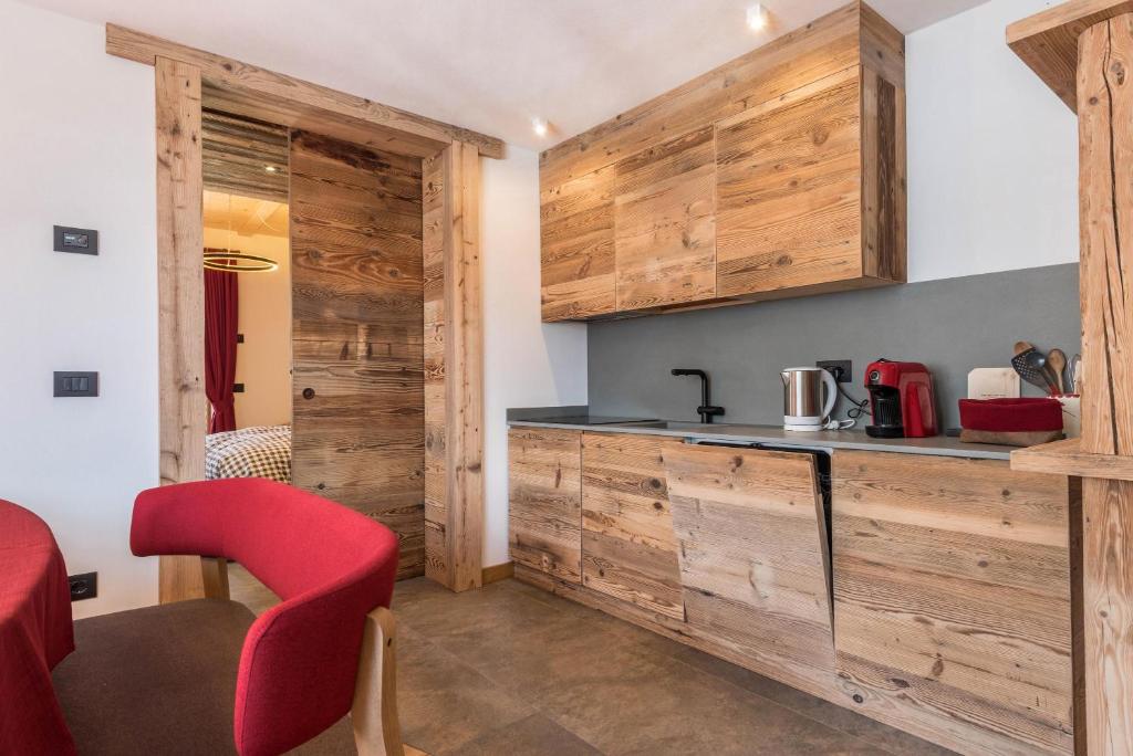 卡纳泽伊Majon Baticher的厨房设有木墙、柜台和红色椅子
