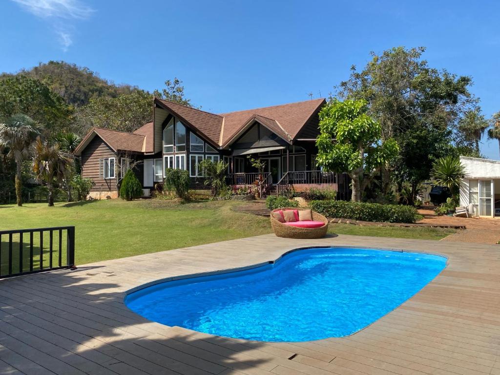 慕斯Kenora Khaoyai Retreats - Private Pool Villa的房屋前有蓝色游泳池的房子