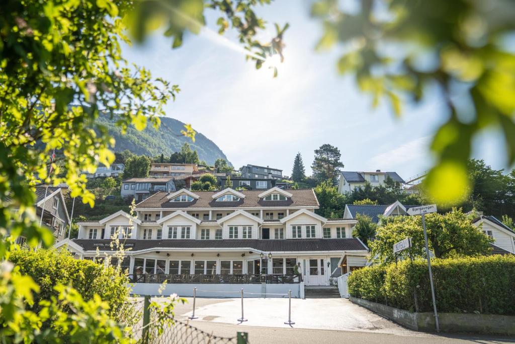 艾于兰Hotel Aurlandsfjord的一座大白色房子,后面有山