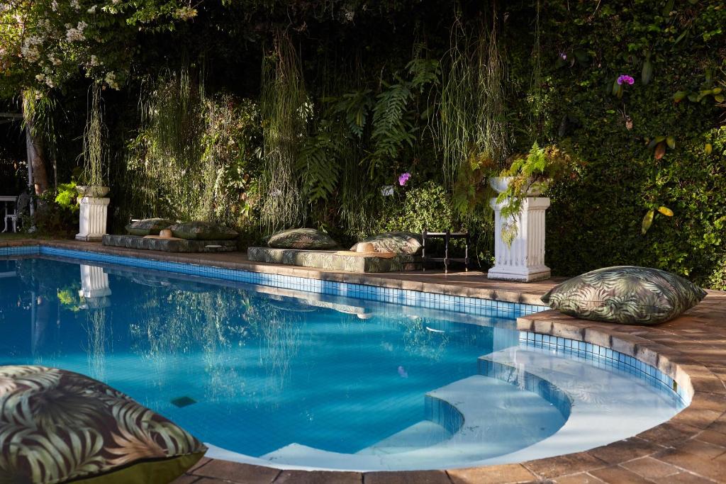 里约热内卢Mama Ruisa Boutique Hotel的庭院内带枕头的游泳池
