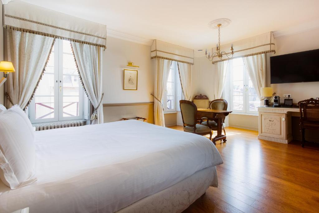 穆兰穆兰巴黎中心美居酒店的卧室配有一张白色大床和一张书桌
