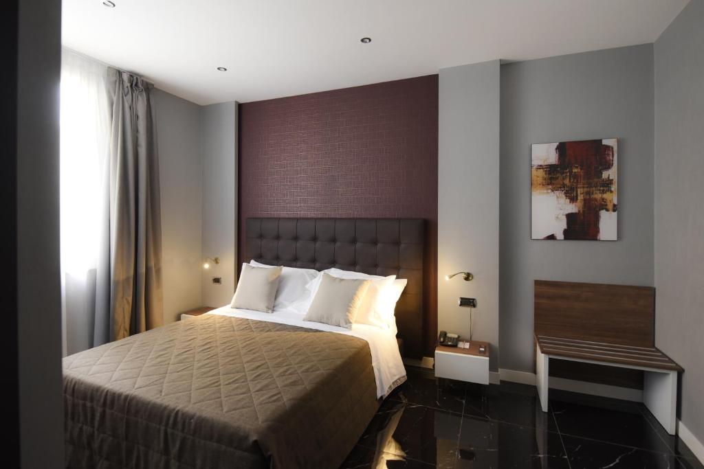 那不勒斯马格里酒店的一间卧室设有一张大床和一个窗户。