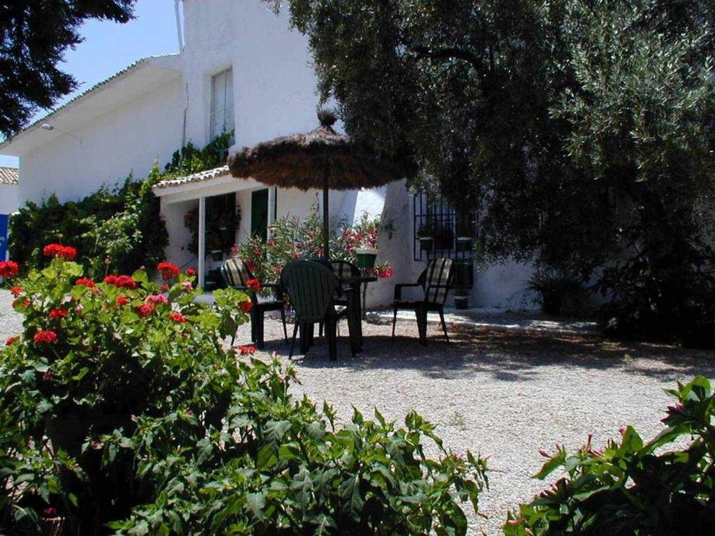 曼查雷亚尔卡萨拉卡特塔乡村酒店的庭院配有桌椅和遮阳伞。