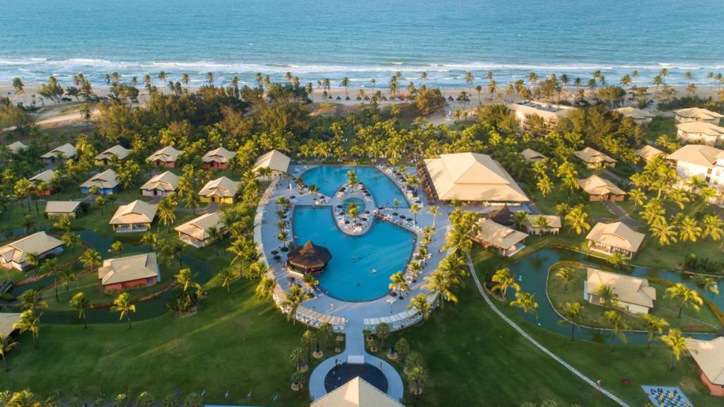 卡姆布库Vila Galé Resort Cumbuco - All inclusive的享有带游泳池和海洋的度假村的空中景致