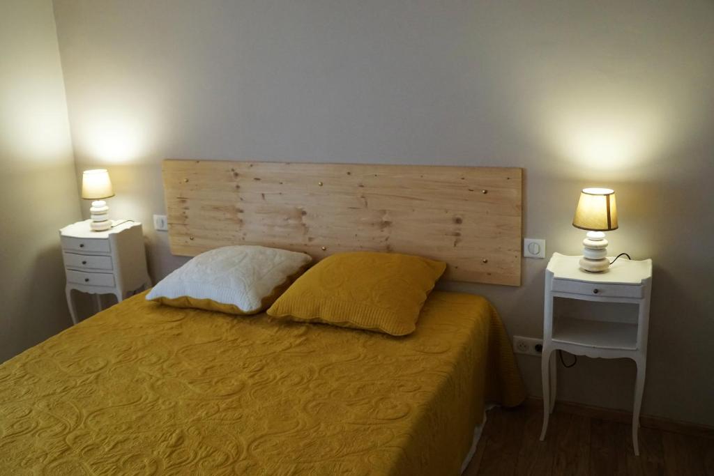 Saint-ThibéryLourecantou的一间卧室配有一张带2个床头柜和2盏灯的床。