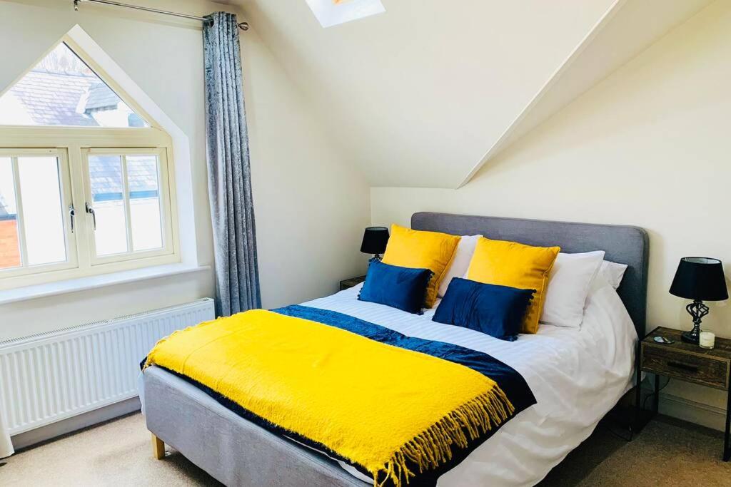 LincolnshireBoutique Townhouse Uphill Lincoln的一间卧室配有黄色和蓝色枕头的床