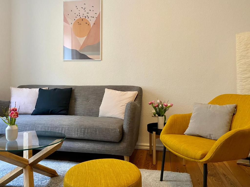 弗伦斯堡Zentrumsnahe schöne Altbauwohnung bis 4 Personen的客厅配有沙发和两把椅子