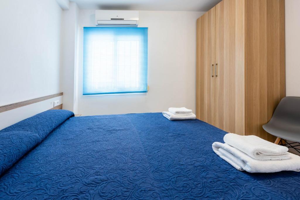 内尔哈EDIFICIO CHAPARIL的一间卧室配有蓝色的床和毛巾