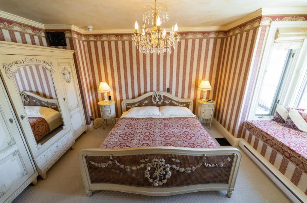 ParrsboroThe Maple Inn的一间卧室配有两张床和吊灯。