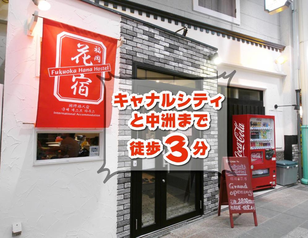 福冈福冈之花旅馆的建筑物一侧有标志的商店