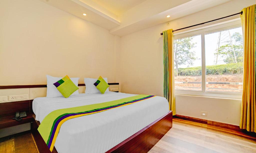 蒙纳Treebo Trend Wanderlust Residency With Mountain View的一间卧室设有一张大床和一个窗户。