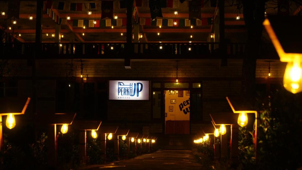 卡索尔PerkUp Hostel的灯火通明的标志在建筑物前