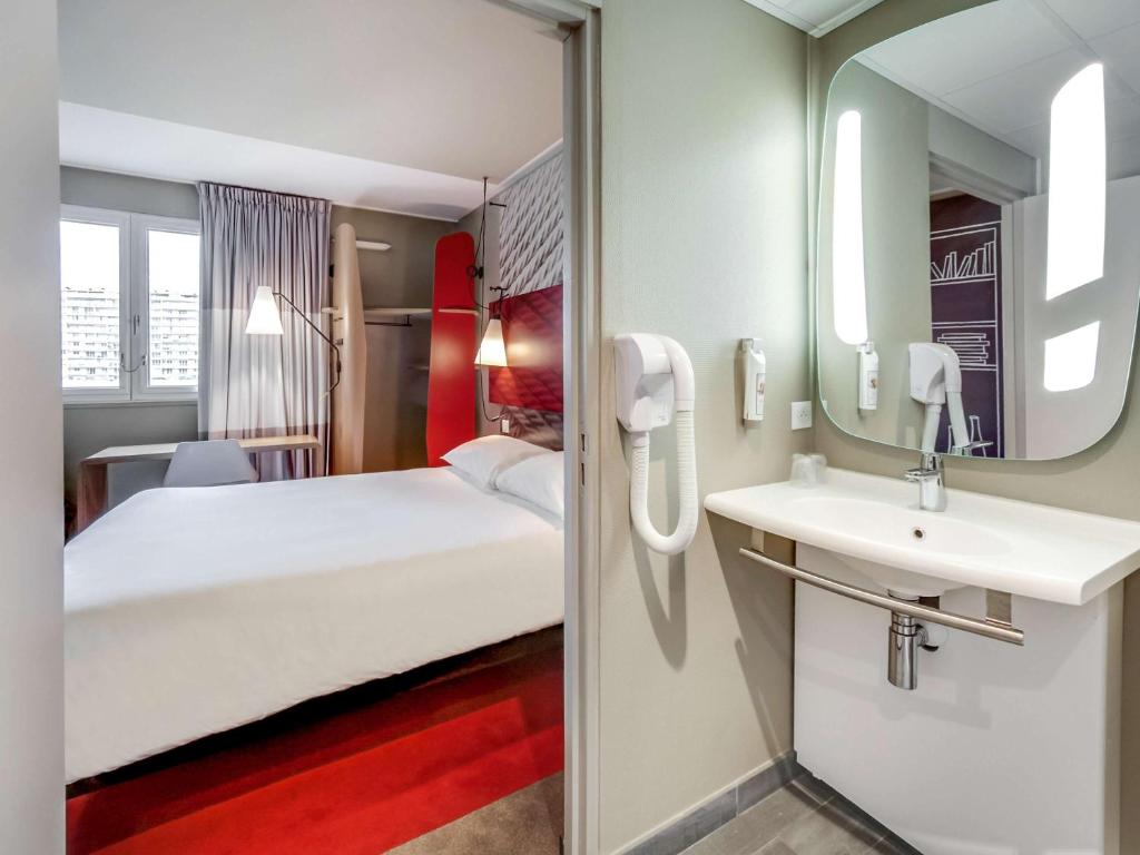 奥尔良宜必思奥尔良中心火车站酒店的一间卧室配有床、水槽和镜子