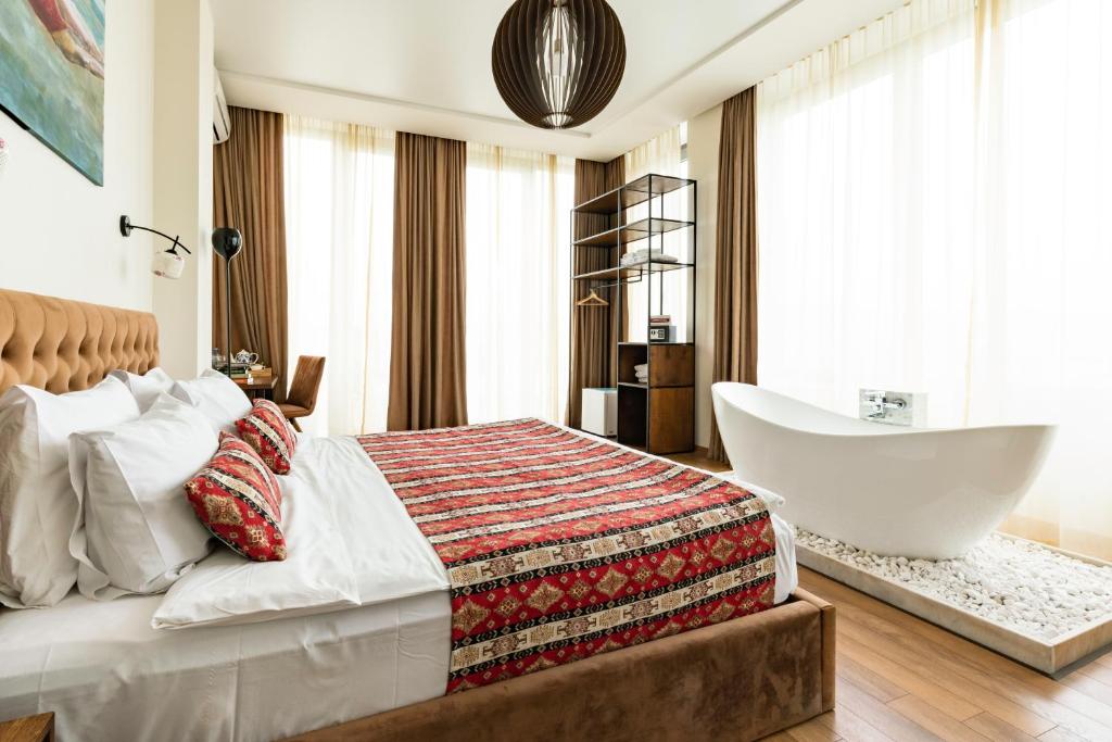 第比利斯Hotel Flower的一间卧室设有一张大床和一个浴缸
