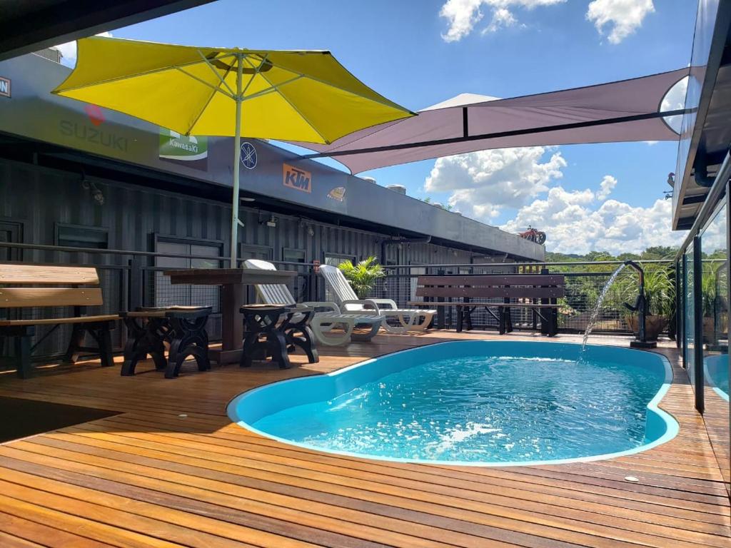 博尼图Hotel Bonito Motobox - HOTEL CONTAINER的甲板上的游泳池,配有遮阳伞
